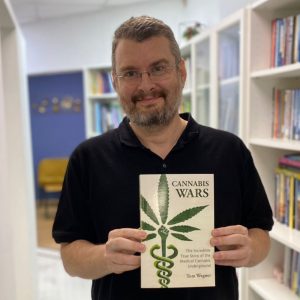 Tom Wegner, holding his book Cannabis Wars