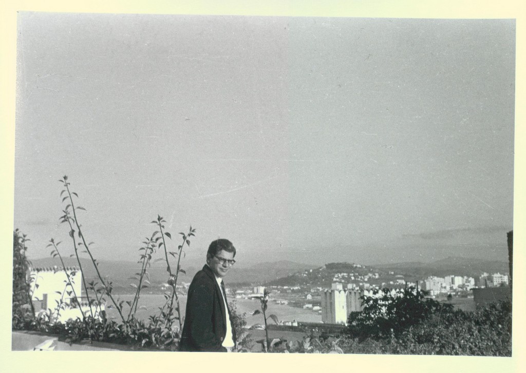 Allen Ginsberg in in black suit jacket, backdrop Tangier