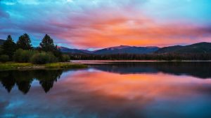 sunrise over a lake with mountains in colorado